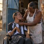 Jovem cadeirante e a mãe, família que busca o BPC LOAS para pessoa com deficiência