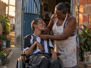Jovem cadeirante e a mãe, família que busca o BPC LOAS para pessoa com deficiência